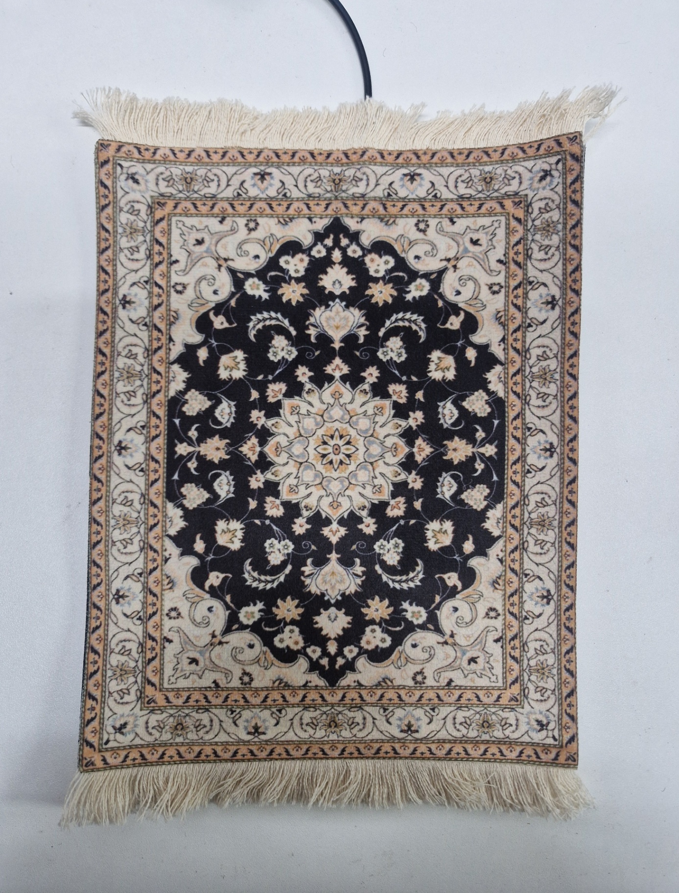 Noir van dichtbij — close-up van de verwarmde muismat met Perzisch design